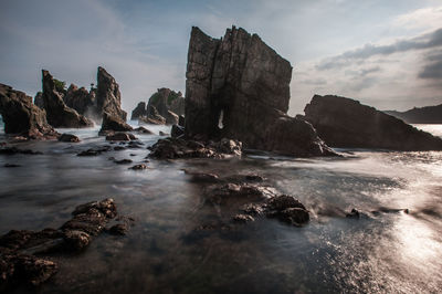 Rocks in sea against sky