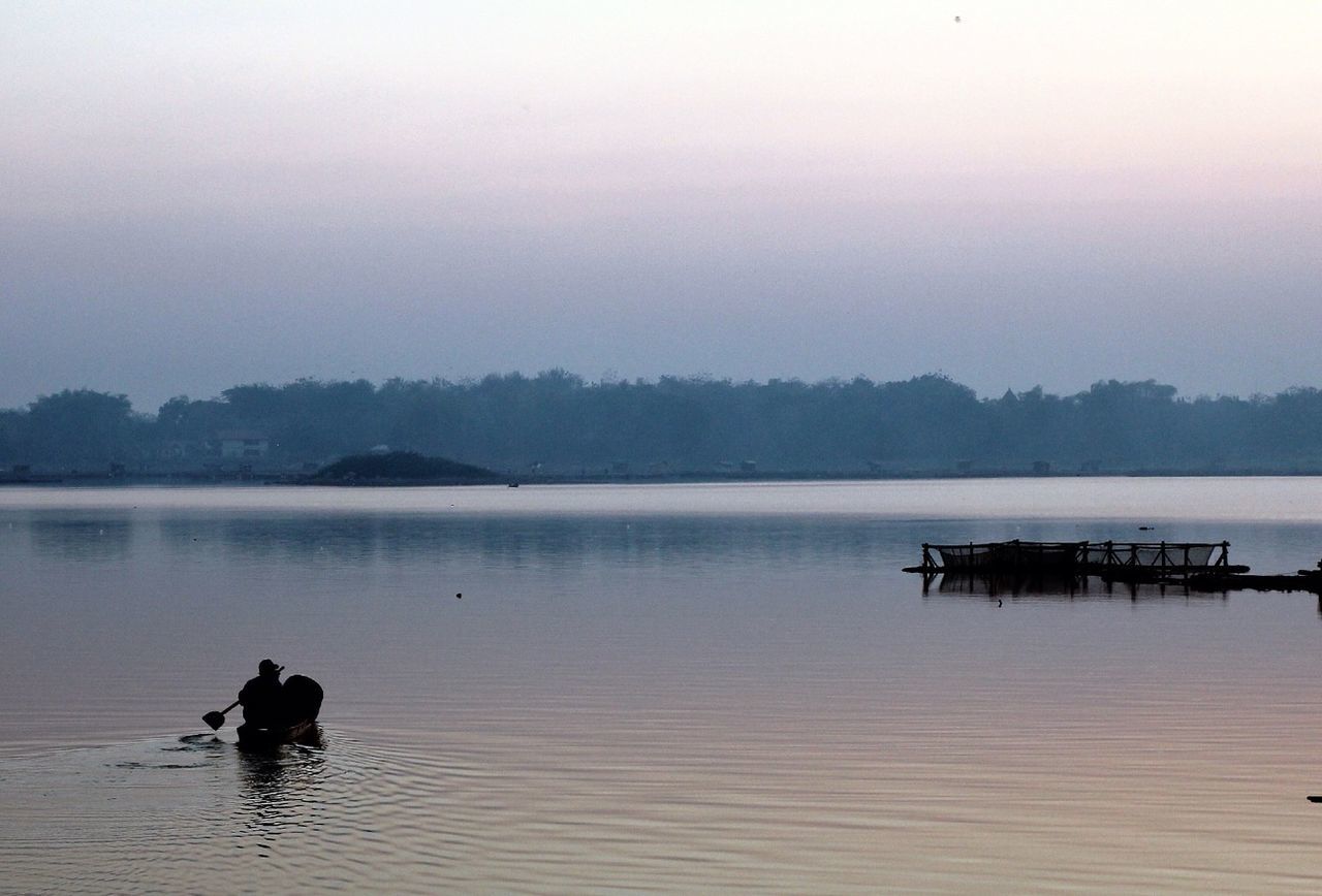 water, lake, nautical vessel, tranquility, tranquil scene, scenics, transportation, boat, beauty in nature, silhouette, reflection, mode of transport, nature, waterfront, sky, sunset, river, idyllic, dusk, fog