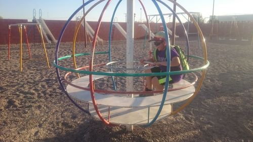 Boy playing on swing in park