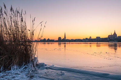 Scenic view of lake against clear sky during sunset