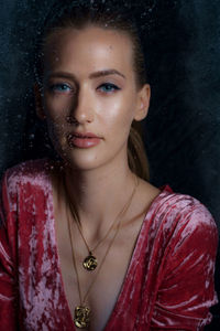 Close-up portrait of beautiful woman with blue eyes seen through window