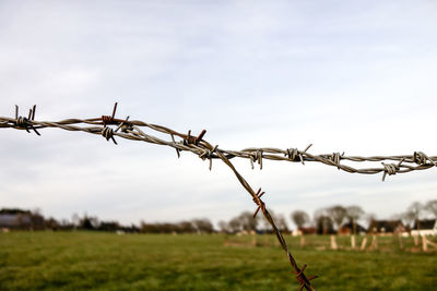 Barbed wire fence on field