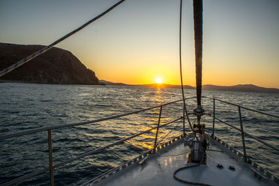 Sailboat sailing on sea against sky during sunset