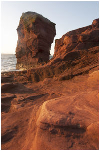 Rock formations on beach against clear sky