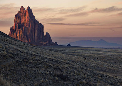 Rock formations on landscape against sky during sunset