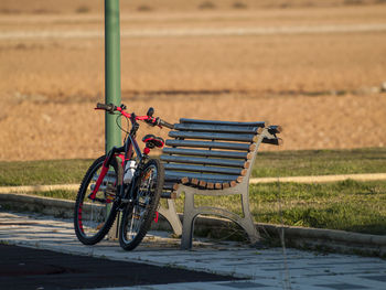 Bicycle parked by bench