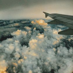 Cropped image of airplane flying over clouds