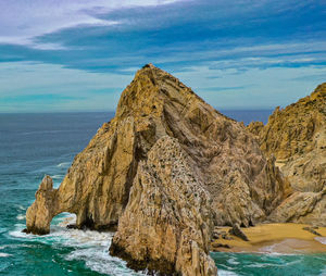 Scenic view of rock formation in sea against sky