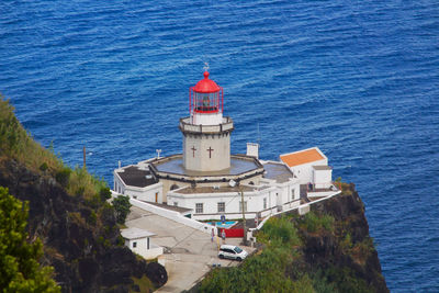 High angle view of lighthouse on building by sea