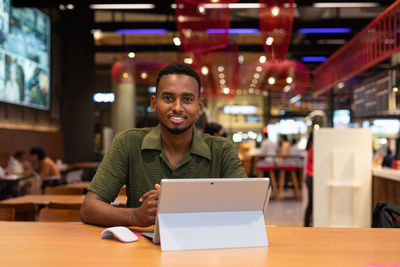 Portrait of young businesswoman using laptop at cafe