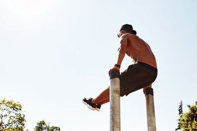 Low angle view of man standing against clear sky