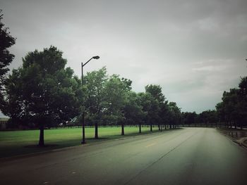 Empty road along trees