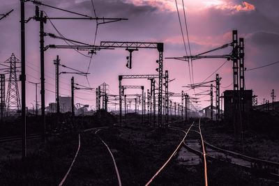 Railroad tracks against sky during sunset