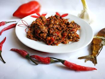 High angle view of food and chili peppers over white background