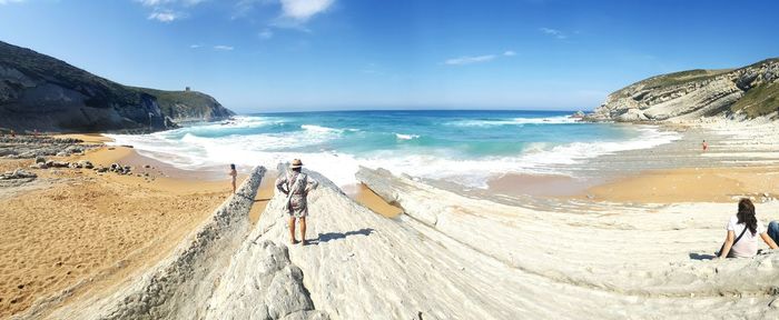 People at beach against blue sky