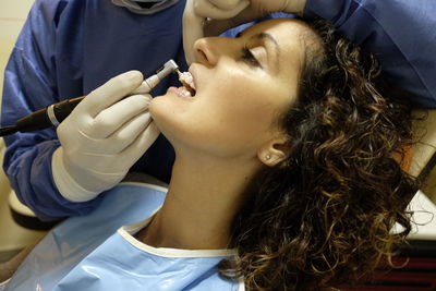 Midsection of doctor examining woman at hospital