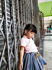 Cute little girl standing against metallic shutter