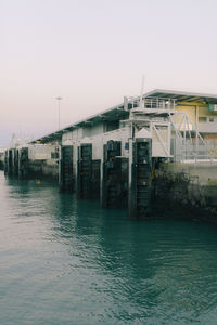 Buildings by sea against clear sky