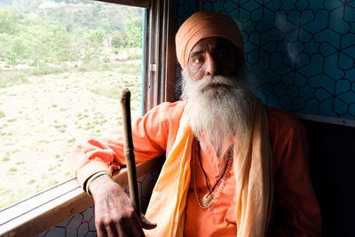 Portrait of man sitting by window