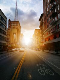 View of city street and buildings at sunset