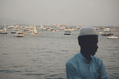 Rear view of man on harbor against sky