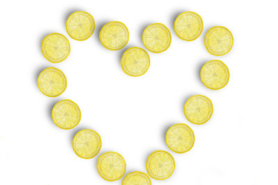 Heart shape made by citrus fruits on white background