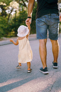 Low section of woman walking on road