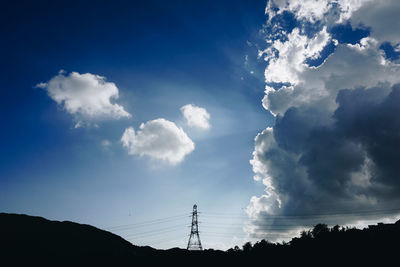 Low angle view of silhouette electricity pylon against sky
