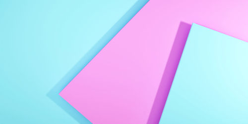 Low angle view of multi colored paper against blue background