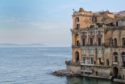 View of building by sea against sky