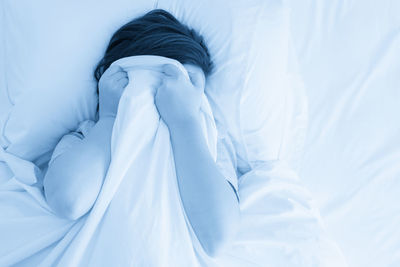 Low section of woman lying on bed