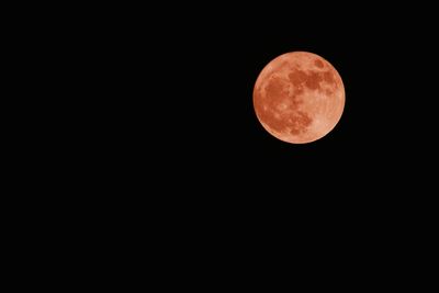 Low angle view of full moon against clear sky at night