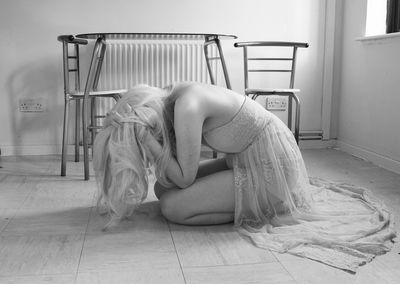 Depressed woman kneeling on floor