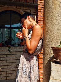 Side view of woman smoking cigarette outdoors