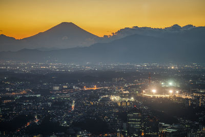 Aerial view of illuminated cityscape against sky at night