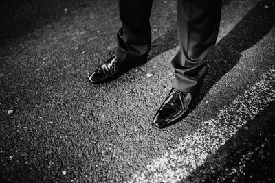 Low section of man standing on road