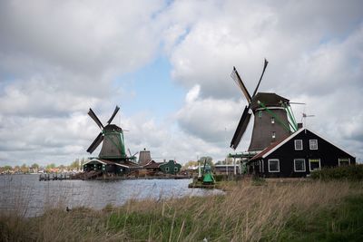 Traditional windmill on landscape against sky