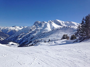 Scenic view of snowcapped mountains against clear blue sky