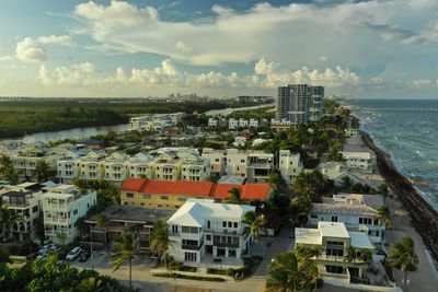 High angle view of buildings and sea against sky