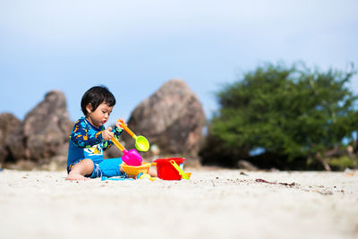 Boy playing with toys on sand