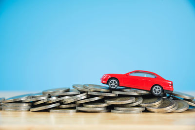 Close-up of red car parked against blue sky