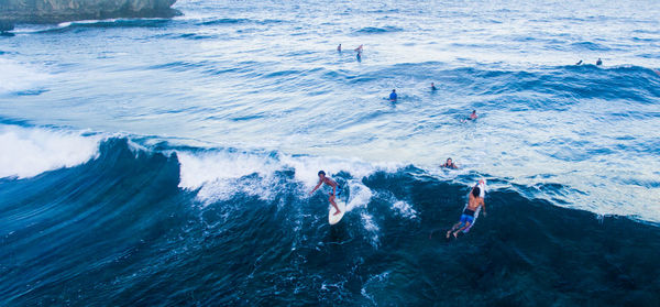 High angle view of people swimming and surfing in sea