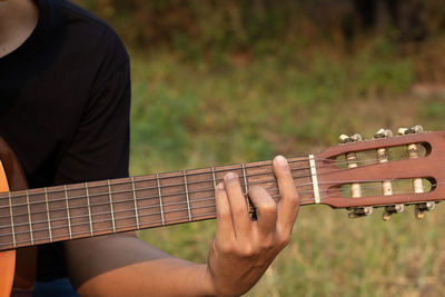 Midsection of man playing guitar