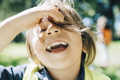 Portrait of cheerful boy with tousled hair in playground