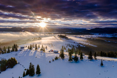 Scenic view of snow covered landscape against sky during sunset