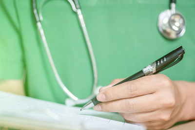 Close-up of man holding cigarette on table