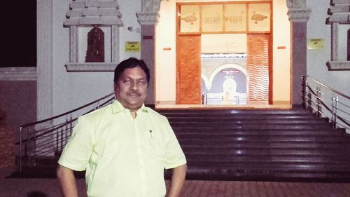 Portrait of smiling man standing against building