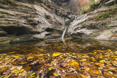 Scenic view of stream amidst rocks during autumn
