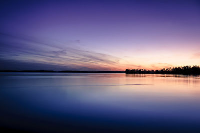 Scenic view of calm lake against sky at dusk