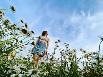 Low angle view of woman walking on field against sky